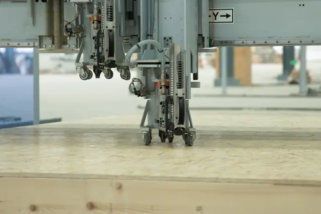 Automated sheathing equipment working on a timber panel